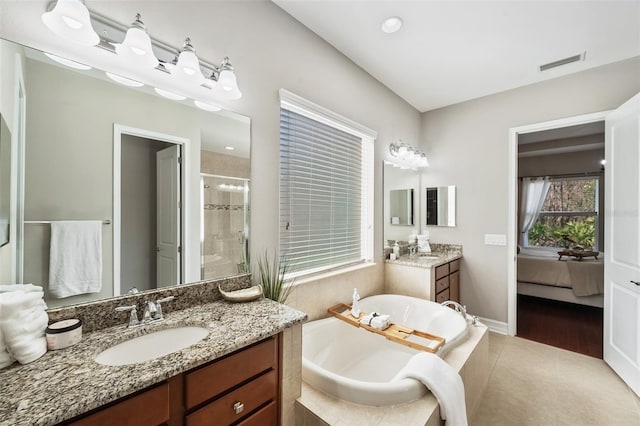 bathroom featuring vanity, plus walk in shower, and tile patterned flooring