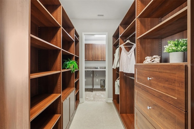 walk in closet with light tile patterned flooring