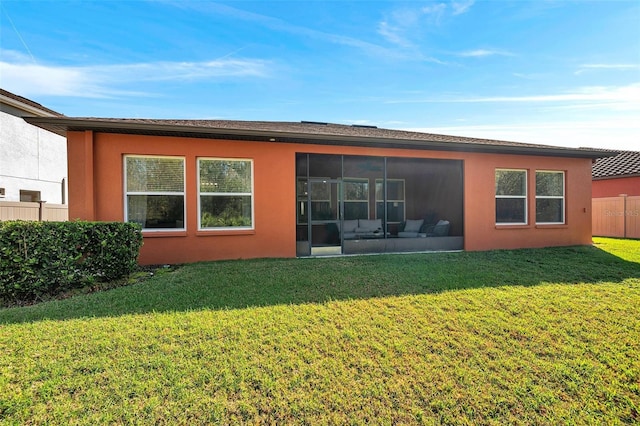 back of property with a yard and a sunroom