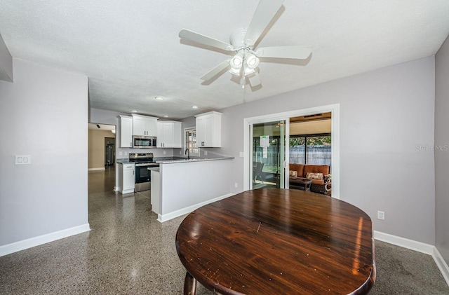 dining room with ceiling fan, sink, and a textured ceiling