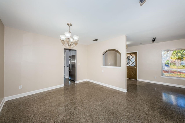 unfurnished room featuring an inviting chandelier