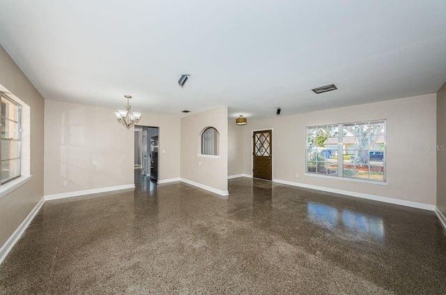 spare room featuring a chandelier