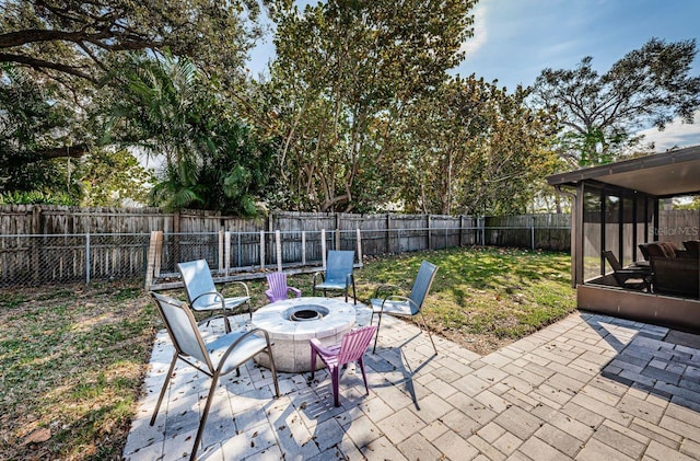 view of patio / terrace featuring an outdoor fire pit and a sunroom