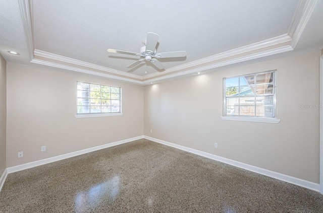 unfurnished room with crown molding, a textured ceiling, ceiling fan, and a tray ceiling