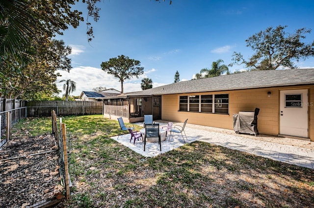 view of yard featuring a fire pit, a patio area, and a sunroom