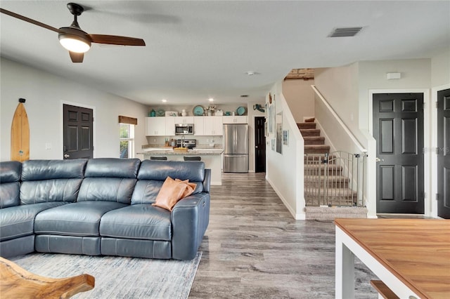 living room featuring ceiling fan and light wood-type flooring