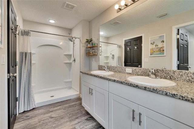 bathroom featuring vanity, wood-type flooring, and walk in shower