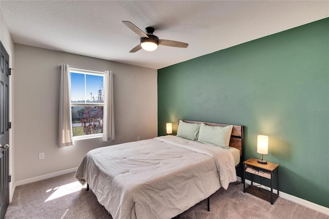 bedroom with a textured ceiling, ceiling fan, and carpet