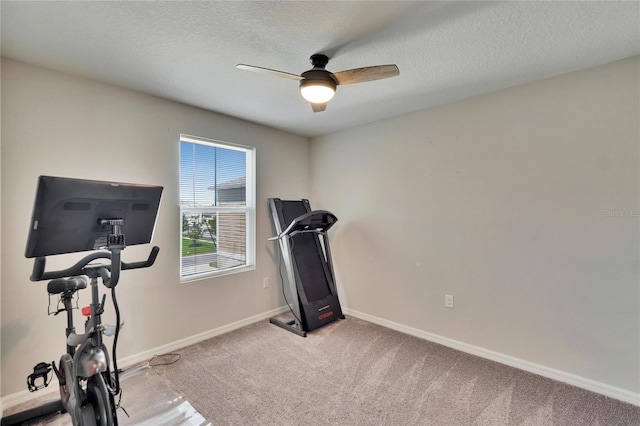 workout room with ceiling fan, light colored carpet, and a textured ceiling