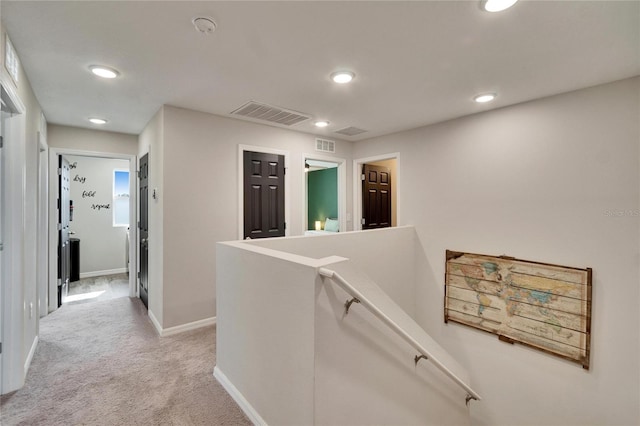 hallway featuring light colored carpet