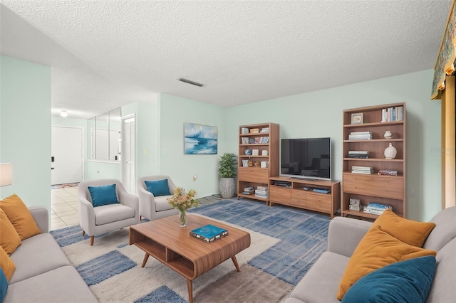 tiled living room featuring visible vents and a textured ceiling