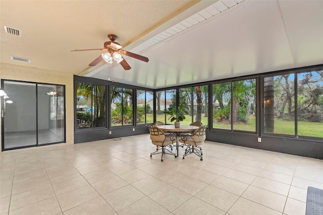 sunroom with a wealth of natural light, visible vents, and ceiling fan