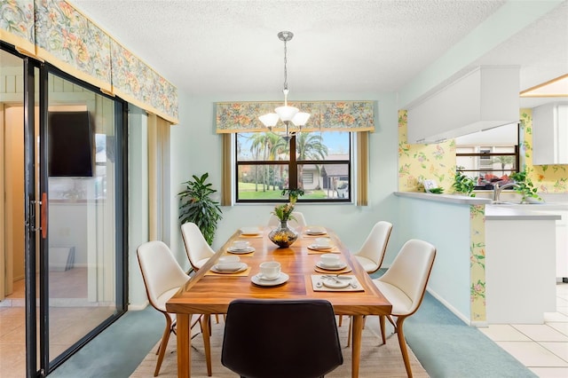 dining room featuring an inviting chandelier, light tile patterned floors, baseboards, and a textured ceiling