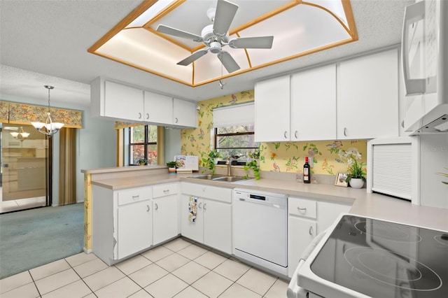 kitchen featuring light countertops, white dishwasher, a sink, and white cabinetry