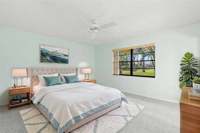 carpeted bedroom with ceiling fan and a textured ceiling