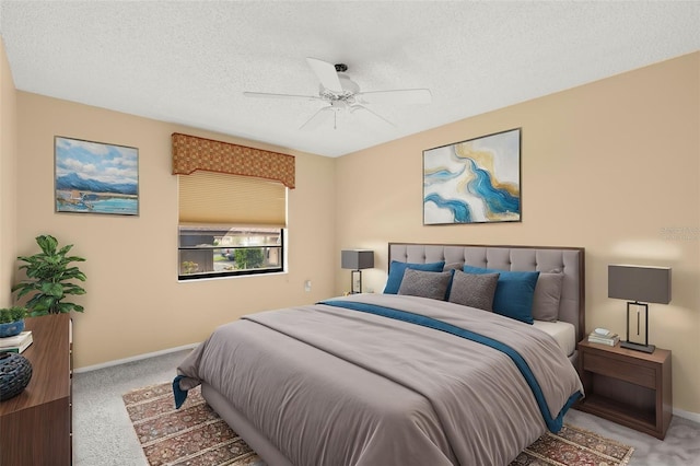 carpeted bedroom featuring a textured ceiling, a ceiling fan, and baseboards