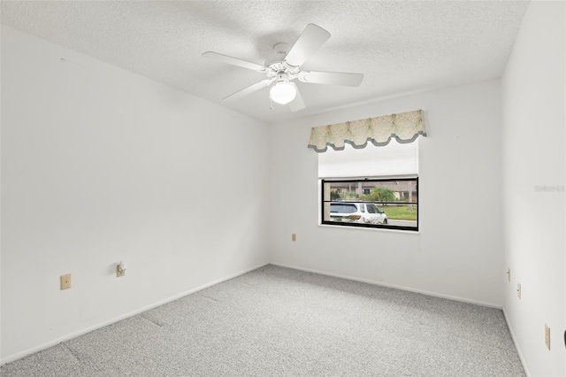 carpeted spare room featuring ceiling fan, baseboards, and a textured ceiling