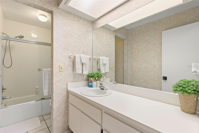 full bath featuring tile patterned flooring, combined bath / shower with glass door, and vanity