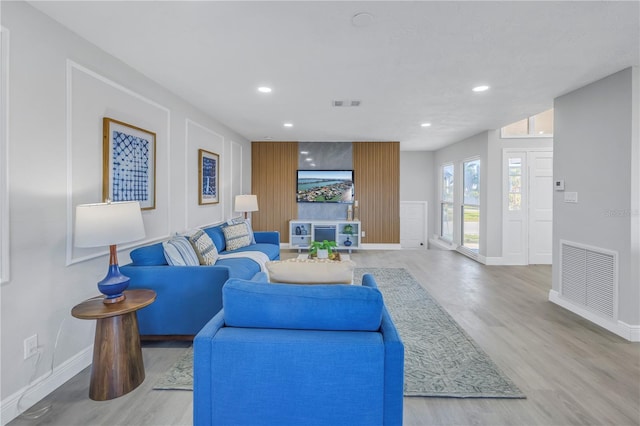 living room with light wood-type flooring, baseboards, visible vents, and recessed lighting