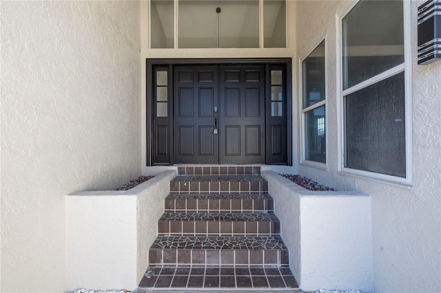 view of exterior entry featuring stucco siding