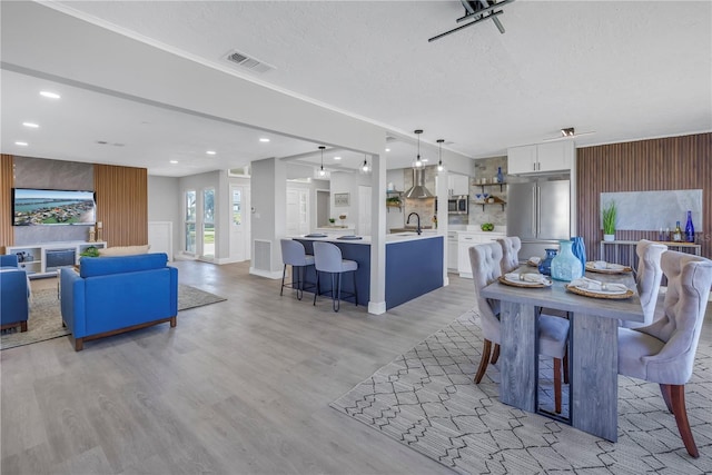 dining room featuring a textured ceiling, recessed lighting, visible vents, and light wood-style floors