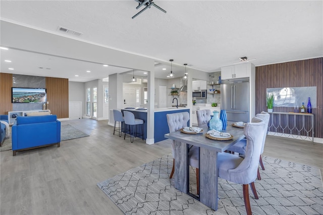 dining room featuring a textured ceiling, light wood-style flooring, visible vents, and recessed lighting