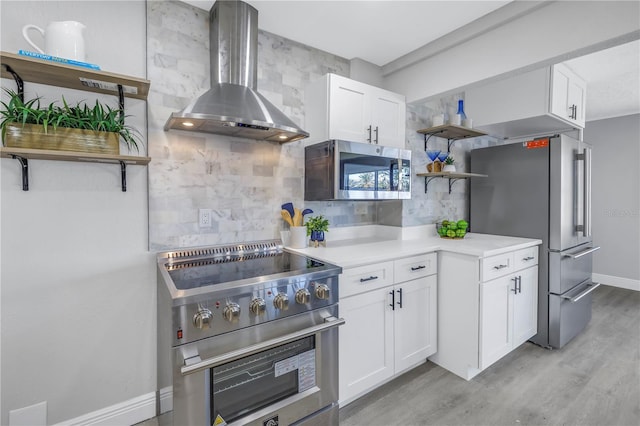 kitchen featuring open shelves, light countertops, appliances with stainless steel finishes, white cabinets, and wall chimney range hood