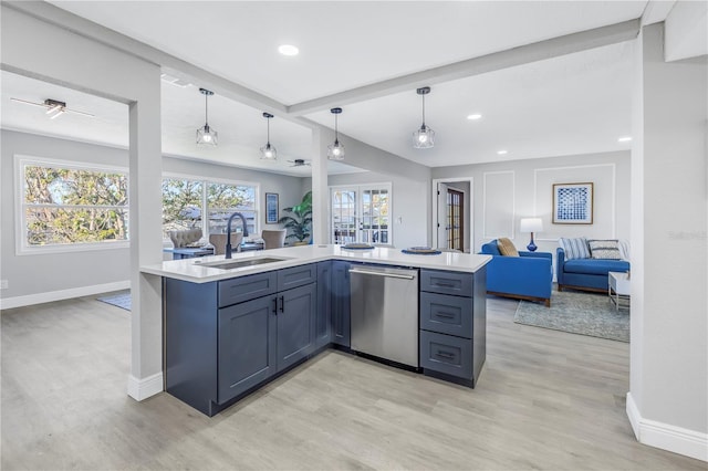 kitchen with open floor plan, hanging light fixtures, light countertops, stainless steel dishwasher, and a sink