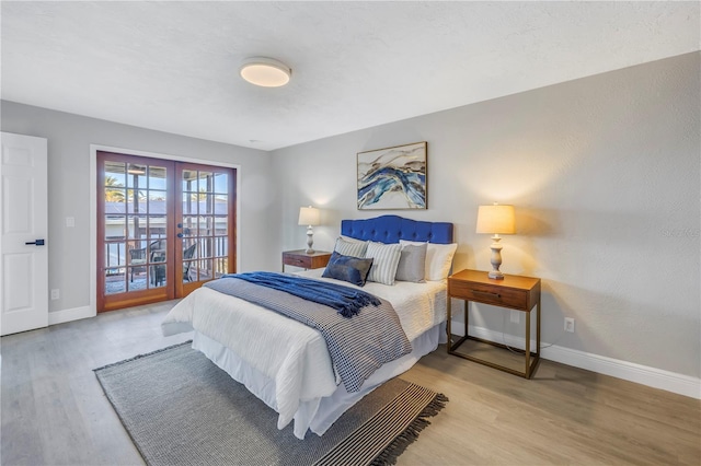 bedroom with access to exterior, french doors, light wood-type flooring, and baseboards