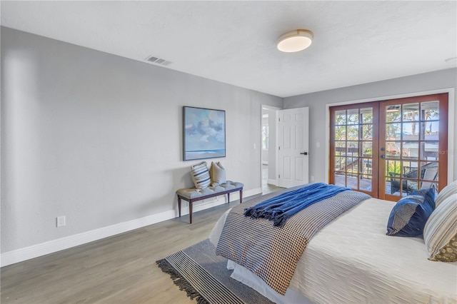 bedroom featuring wood finished floors, visible vents, baseboards, access to outside, and french doors