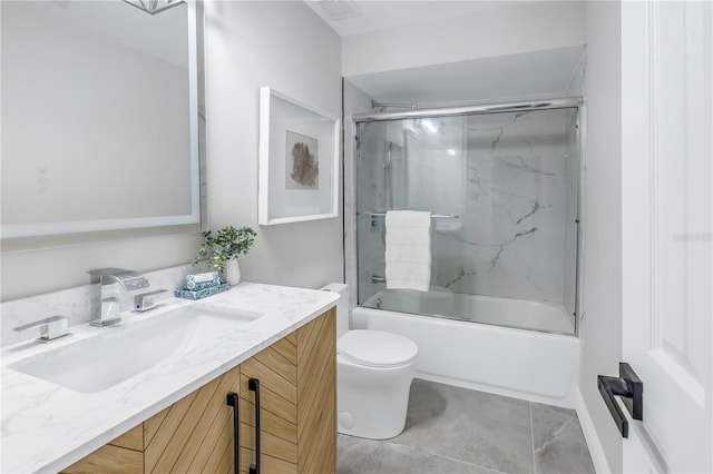 full bathroom featuring visible vents, toilet, shower / bath combination with glass door, tile patterned floors, and vanity