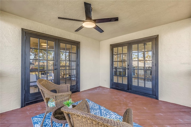 entrance to property featuring stucco siding, ceiling fan, and french doors