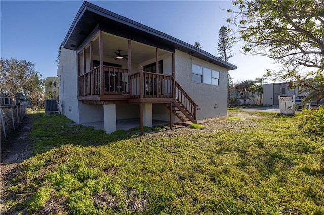 back of house with a yard, ceiling fan, stairway, and fence