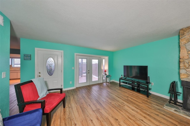 14505 Catalina Cir, Seminole, FL 33776 - living room featuring a textured ceiling, light wood-type flooring, and french doors