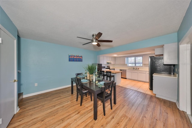 14505 Catalina Cir, Seminole, FL 33776 - dining space with ceiling fan, light hardwood / wood-style floors, sink, and a textured ceiling