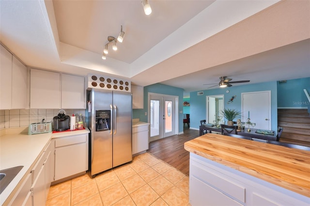 14505 Catalina Cir, Seminole, FL 33776 - kitchen featuring french doors, a tray ceiling, stainless steel fridge with ice dispenser, and white cabinets