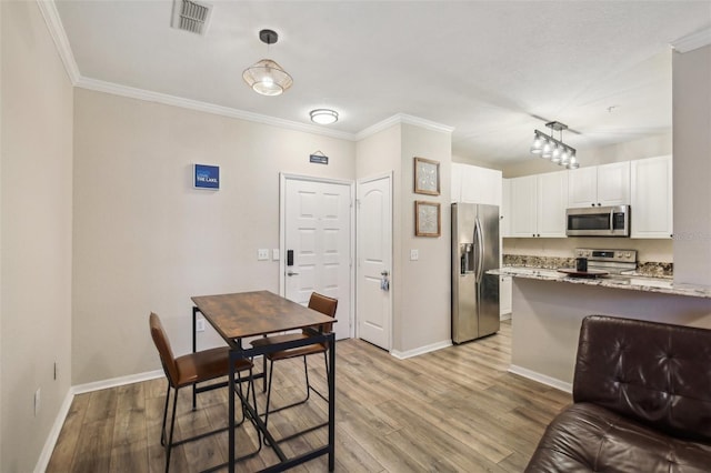 4221 W Spruce St Unit 1414, Tampa, FL 33607 - kitchen featuring white cabinetry, appliances with stainless steel finishes, light stone counters, and light hardwood / wood-style floors
