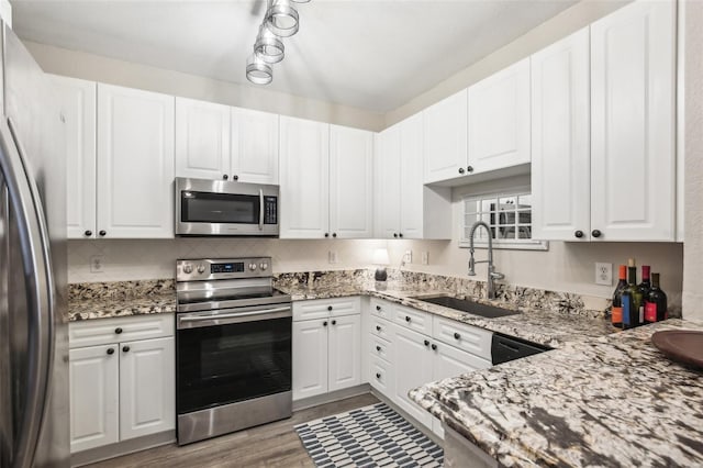 4221 W Spruce St Unit 1414, Tampa, FL 33607 - kitchen with light stone counters, sink, stainless steel appliances, and white cabinets