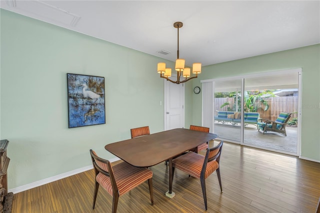 dining room featuring baseboards, visible vents, an inviting chandelier, and wood finished floors