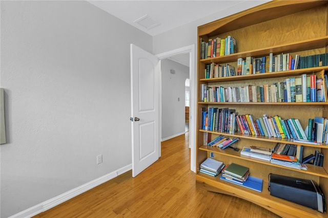 living area with visible vents, baseboards, and wood finished floors