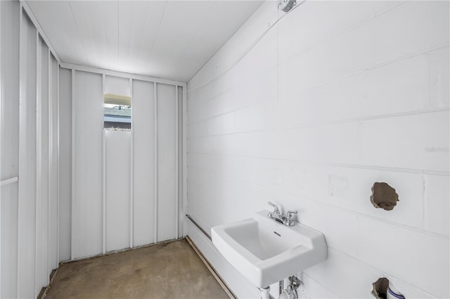 bathroom with a sink and unfinished concrete floors