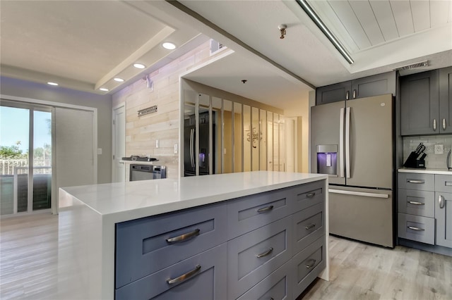 7432 Sunshine Skyway Ln S Unit 206, Saint Petersburg, FL 33711 - kitchen featuring light hardwood / wood-style floors, decorative backsplash, gray cabinetry, and stainless steel fridge with ice dispenser