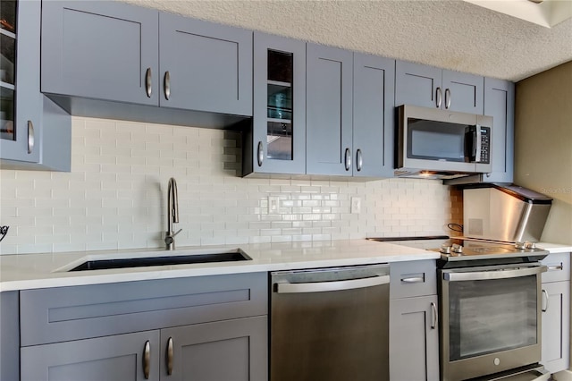 7432 Sunshine Skyway Ln S Unit 206, Saint Petersburg, FL 33711 - kitchen with appliances with stainless steel finishes, sink, tasteful backsplash, and a textured ceiling