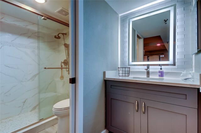 7432 Sunshine Skyway Ln S Unit 206, Saint Petersburg, FL 33711 - bathroom with vanity, a shower with door, toilet, and backsplash