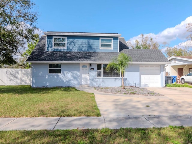 traditional-style house with an attached garage, concrete driveway, a shingled roof, and a front yard