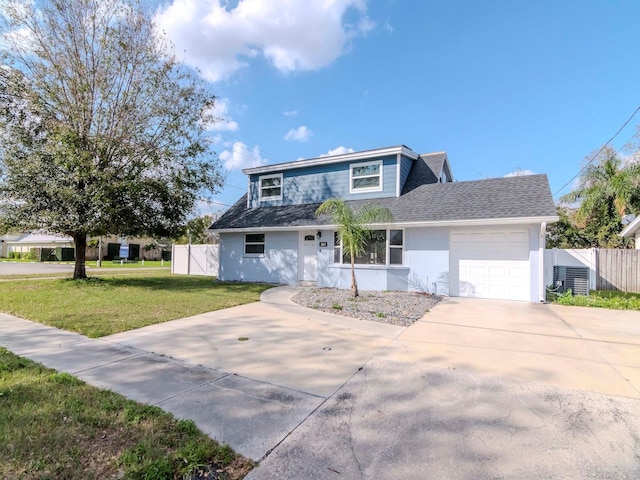 view of front of home featuring an attached garage, fence, driveway, roof with shingles, and a front yard