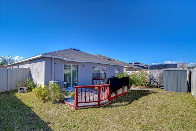 rear view of property featuring a yard and central AC