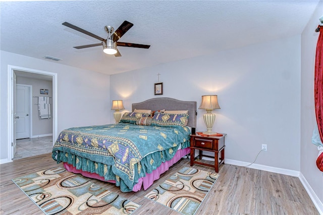 bedroom featuring ceiling fan, a textured ceiling, and light hardwood / wood-style flooring