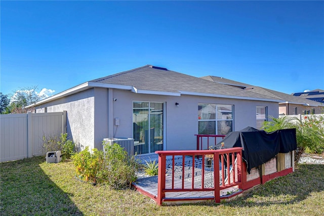 rear view of house featuring a wooden deck and a yard