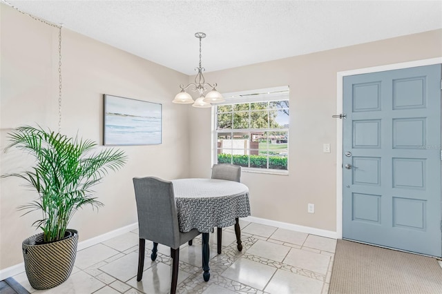 dining area featuring an inviting chandelier, light tile patterned flooring, baseboards, and a textured ceiling